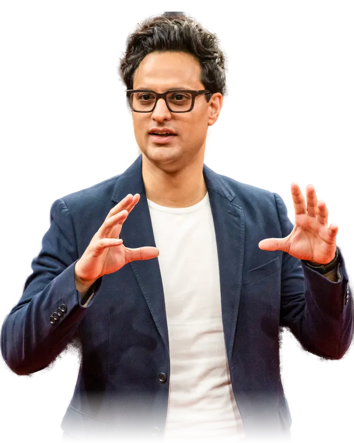 Koni Arora auf der Bühne, erklärt mit beiden Händen