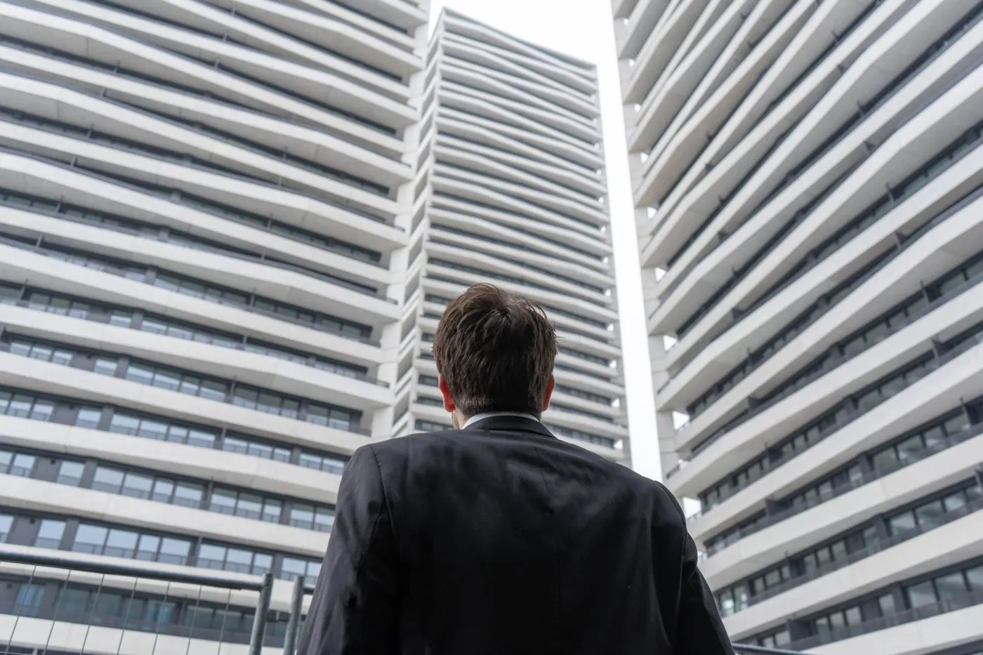 Mann im Anzug vor den Türmen von THREE POINT Apartments